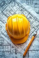 Yellow safety helmet rests on blueprints with a pencil on a construction table photo