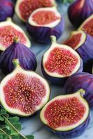 Freshly sliced figs displaying vibrant color and intricate texture on a dark background photo
