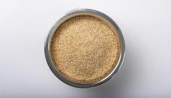 Small container containing quinoa grains, placed in the center of a white background photo