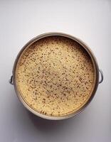 Small container containing quinoa grains, placed in the center of a white background photo