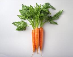 Some carrots are bright orange with green leaves, standing out against the white background photo