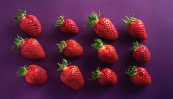 Several strawberries separated on a dark purple background photo