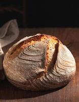 Sourdough bread with visible texture, wooden background photo