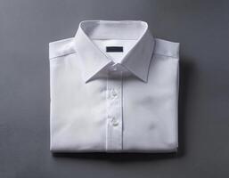 A neatly folded white shirt over a gray background photo
