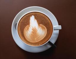 Cappuccino coffee with foam latte art on brown background photo