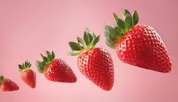 Flying red strawberries on pastel pink background photo