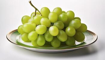 A plate of shiny green grapes on a clean white background photo