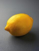 Bright yellow lemon on a gray background photo