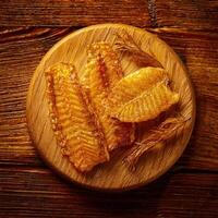 Dried fish on wooden plate on a wooden table photo
