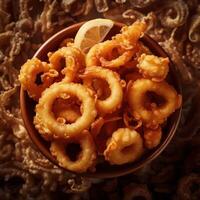A bowl of fried squid with a slice of lemon photo