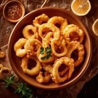 Fried calamari in a bowl with lemon slices photo
