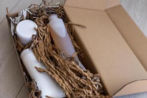 Eco-friendly packaging with personal care products in a cardboard box on a light floor photo