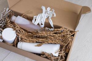 Eco-friendly packaging with personal care products in a cardboard box on a light floor photo