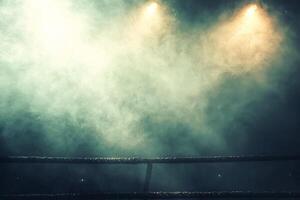 boxing ring features illuminated ropes and a hazy atmosphere with glowing spotlights cutting through the smoke enhancing the drama of the Fight Night event. photo