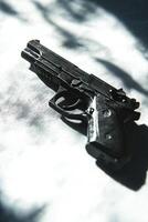 composition highlights a paintball gun positioned against a white background focusing on its trigger and hopper while capturing realistic details in bright light. photo