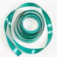 vibrant gymnastic ribbon lays in a spiral formation on a white background highlighting its smooth texture and rich color. Soft shadows create an artistic effect in bright studio light. photo