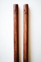 cricket wicket set features two wooden stumps with bails resting on top highlighting the rich wood texture and soft shadows from overhead lighting. photo
