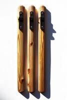 A cricket wicket set with bails rests against a white background highlighting the natural woods texture and markings under soft shadows emphasizing a minimalist aesthetic. photo