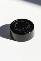 close up displays a hockey puck with a textured surface emphasizing its embossed logo against a bright white background offering a minimalist aesthetic. photo