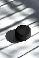 close up view highlights the textured surface and embossed logo of a hockey puck beautifully positioned against a white background with soft shadows and bright illumination. photo