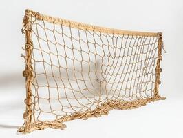visual features a volleyball net neatly bundled on a white surface emphasizing the intricate netting and metal components under bright studio lighting. photo