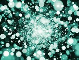 An explosion of turquoise dots and particles radiates outward from a central point, set against a stark black background, evoking a sense of dynamic energy and luminous movement. photo