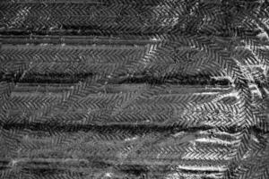 Black and white pattern of overlapping tractor tire tracks on agricultural field photo