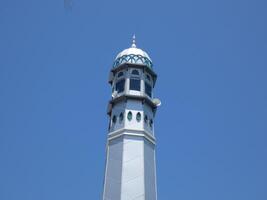 Muslim mosque. Mosque minaret with copper-covered dome against azure sky. emblematic of Ramadan and Islam. photo