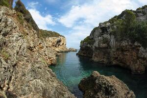 A rocky cliff with water in the middle photo