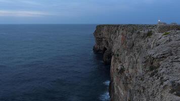 A cliff with a lighthouse on top photo