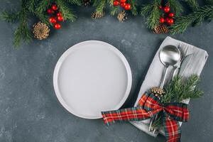 Christmas dinner table setting. White kraft with cutlery and festive decoration on table. Top view photo