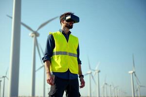 construction worker with outfit wearing VR headset with wind turbine in background photo