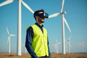 construction worker with outfit wearing VR headset with wind turbine in background photo