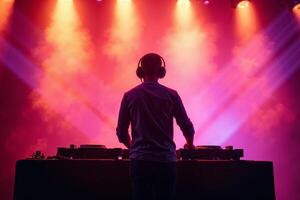 D.J. man standing in concert hall with smoke and colorful light enjoy music festival photo