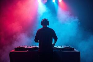 D.J. man standing in concert hall with smoke and colorful light enjoy music festival photo