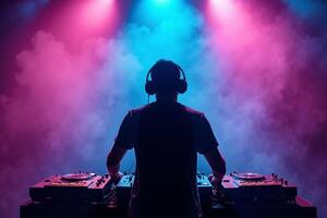 D.J. man standing in concert hall with smoke and colorful light enjoy music festival photo