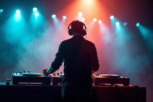 D.J. man standing in concert hall with smoke and colorful light enjoy music festival photo
