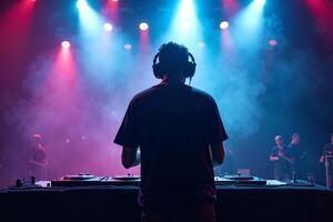 D.J. man standing in concert hall with smoke and colorful light enjoy music festival photo