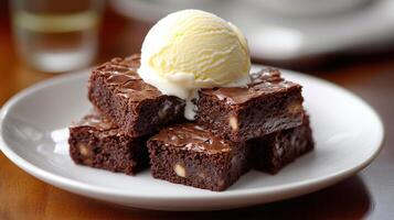 Brownies served with vanilla ice cream melting on top, on a white plate photo