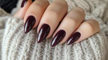 Two hands expertly manicured with a deep purple polish photo