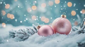 Pink baubles resting in snow with a snow-covered branch and bokeh lights photo