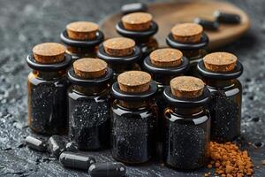 Charcoal Supplement Bottles and Capsules on Dark Background for Health and Wellness Concepts photo