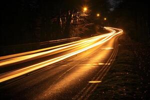 Nighttime Long Exposure of Curved Road with Streaking Headlights in a Forest Setting photo