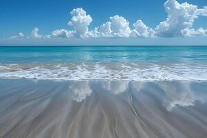 A beach with waves and clouds reflected in the water photo