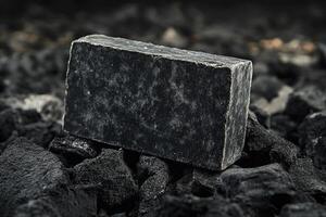 A black soap bar sitting on top of a pile of coal photo