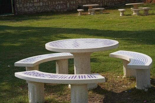A table and two benches in a park photo
