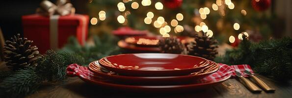 Festive holiday dinner setting with red plates, pinecones, and Christmas decorations photo