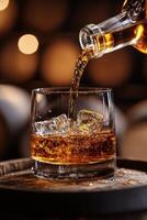 Pouring a rich amber whiskey over ice in a glass, showcasing craftsmanship and tradition photo