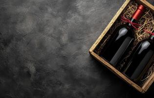 Elegant wooden box containing two wine bottles with red corks on a textured dark surface photo