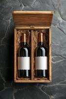 Elegant red wine bottles in a wooden box with straw, showcasing a rustic presentation for gifting photo